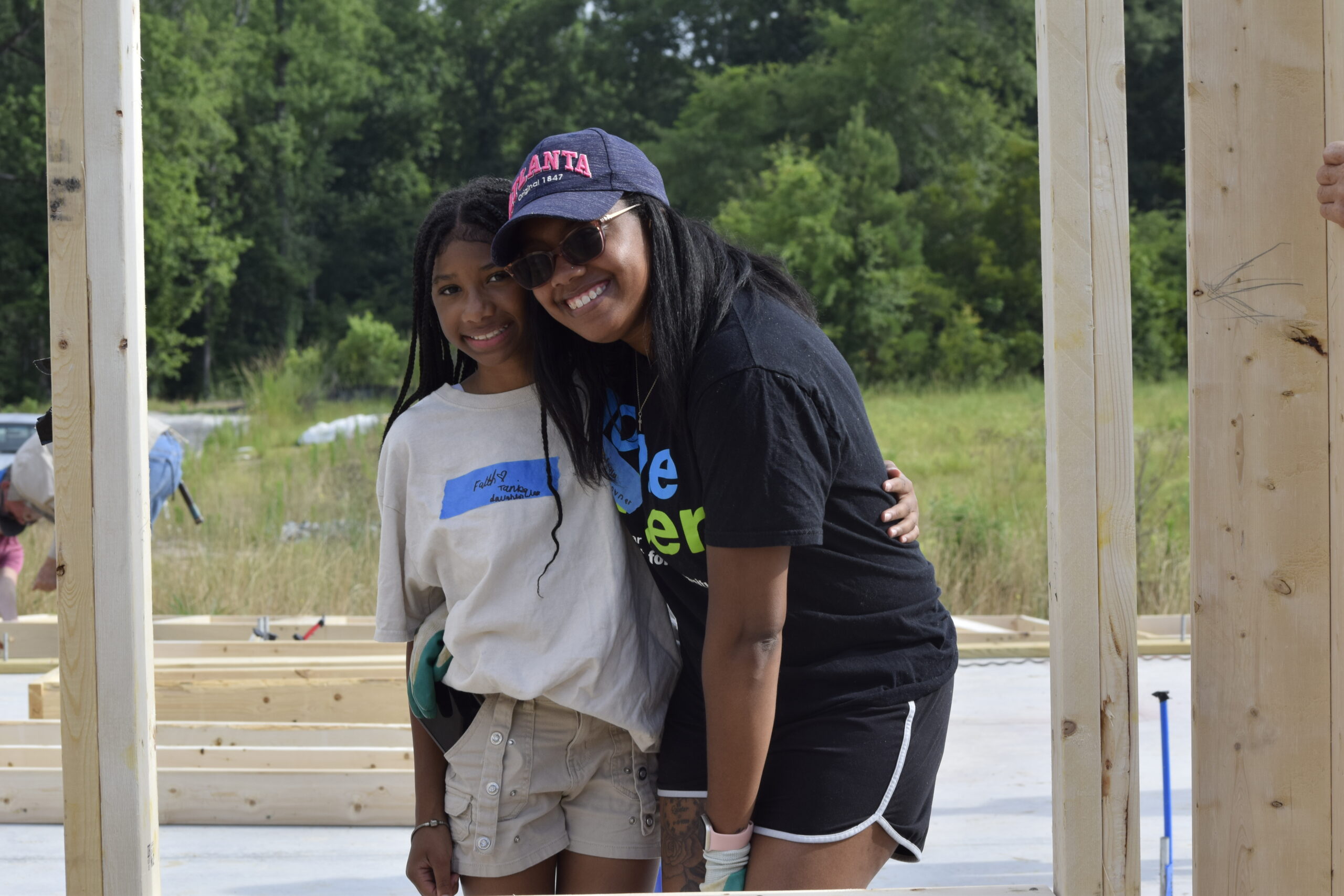 Homeowner and daughter at wall raising, smiling