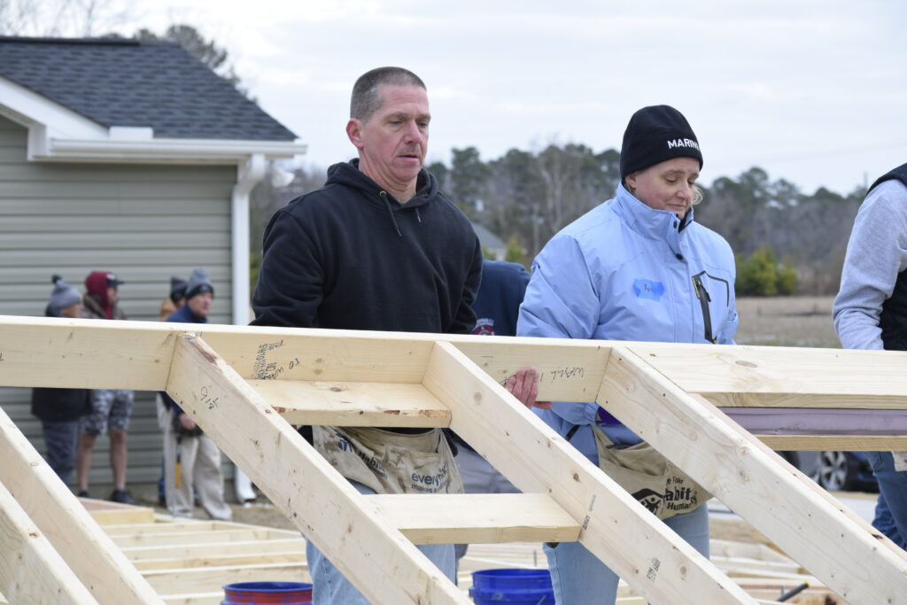 Volunteers raising a wall